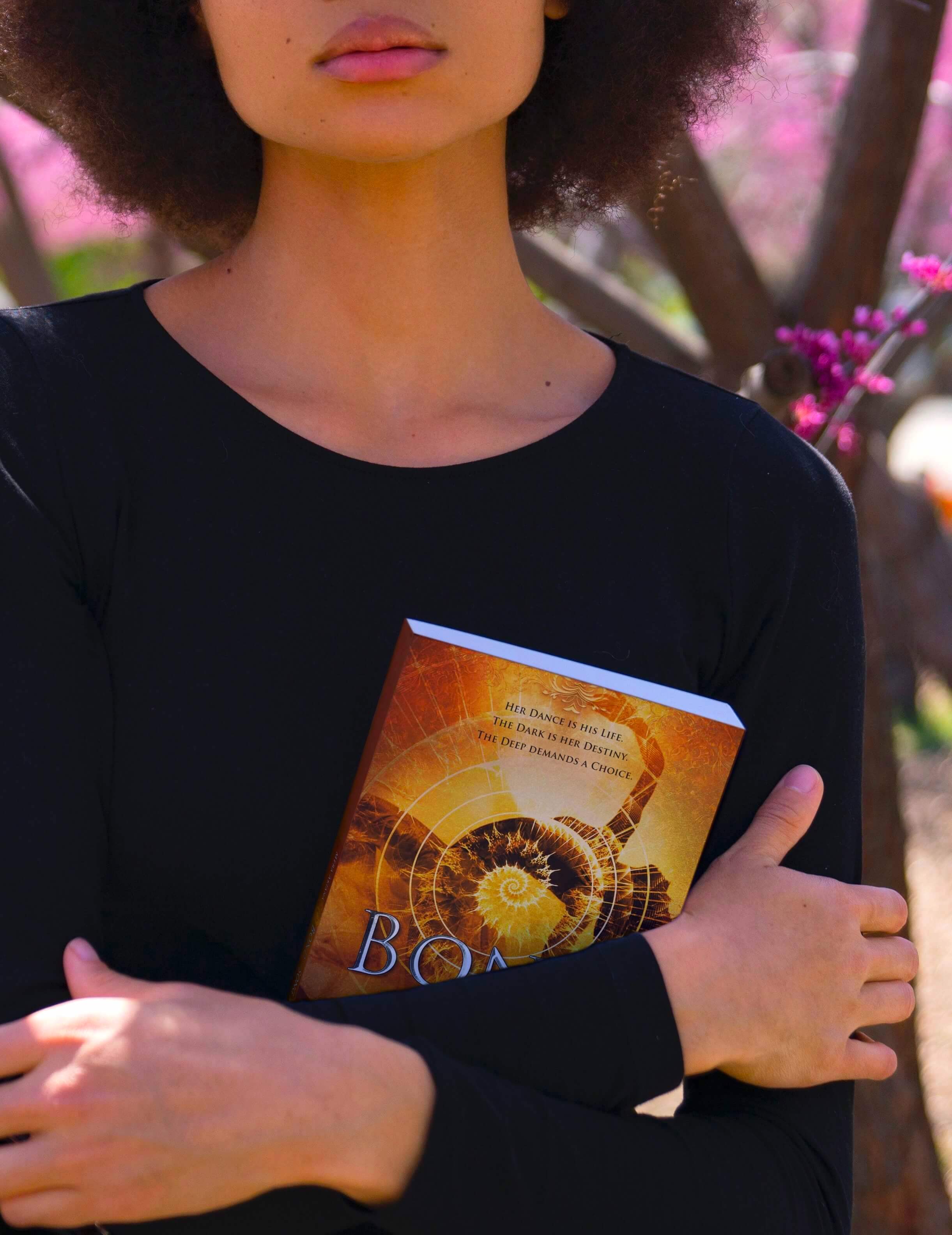 Woman holding fantasy romance novel Bond and Song