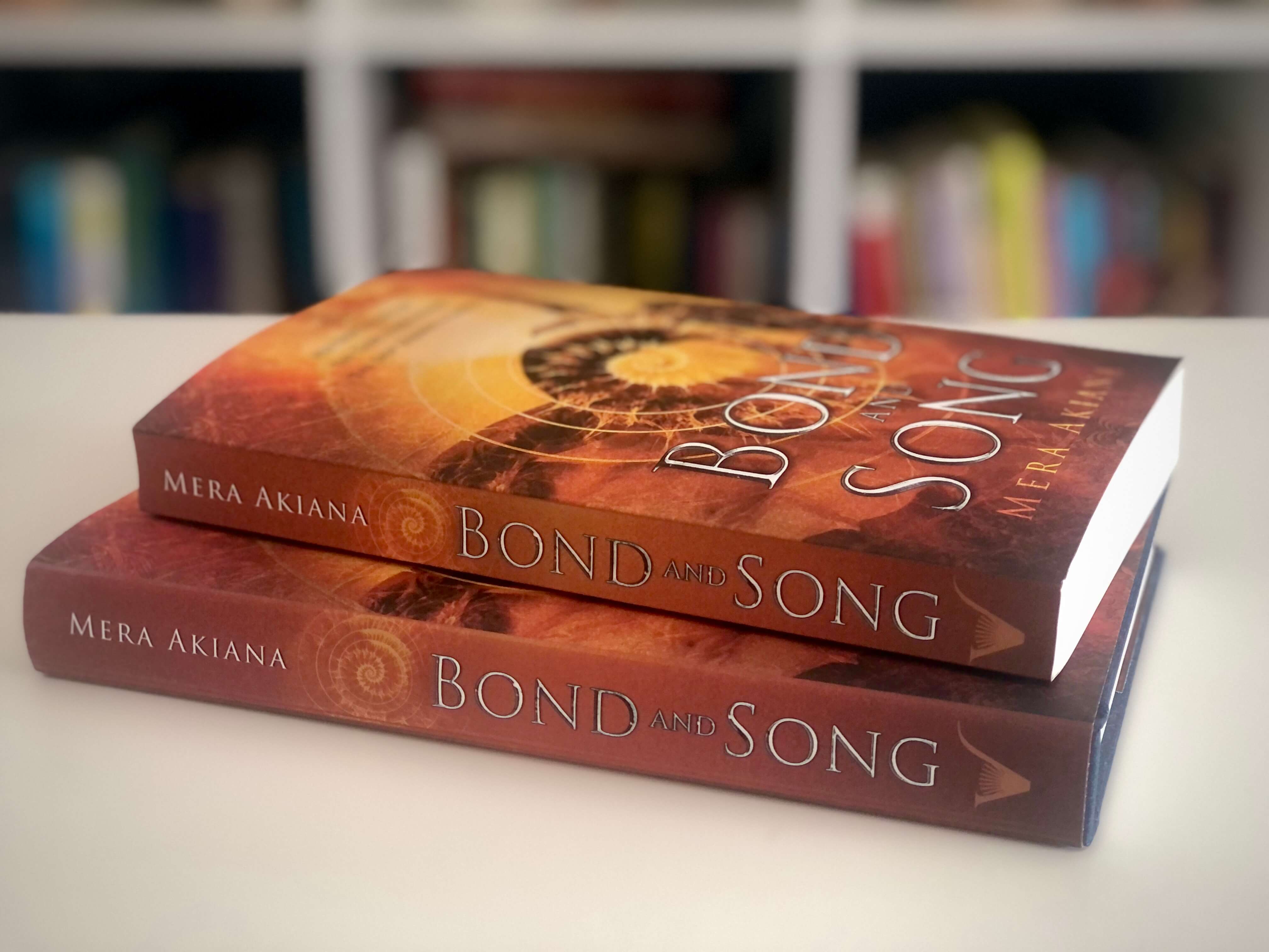 two copies of novel Bond and Song: paperback lying on top of hardcover