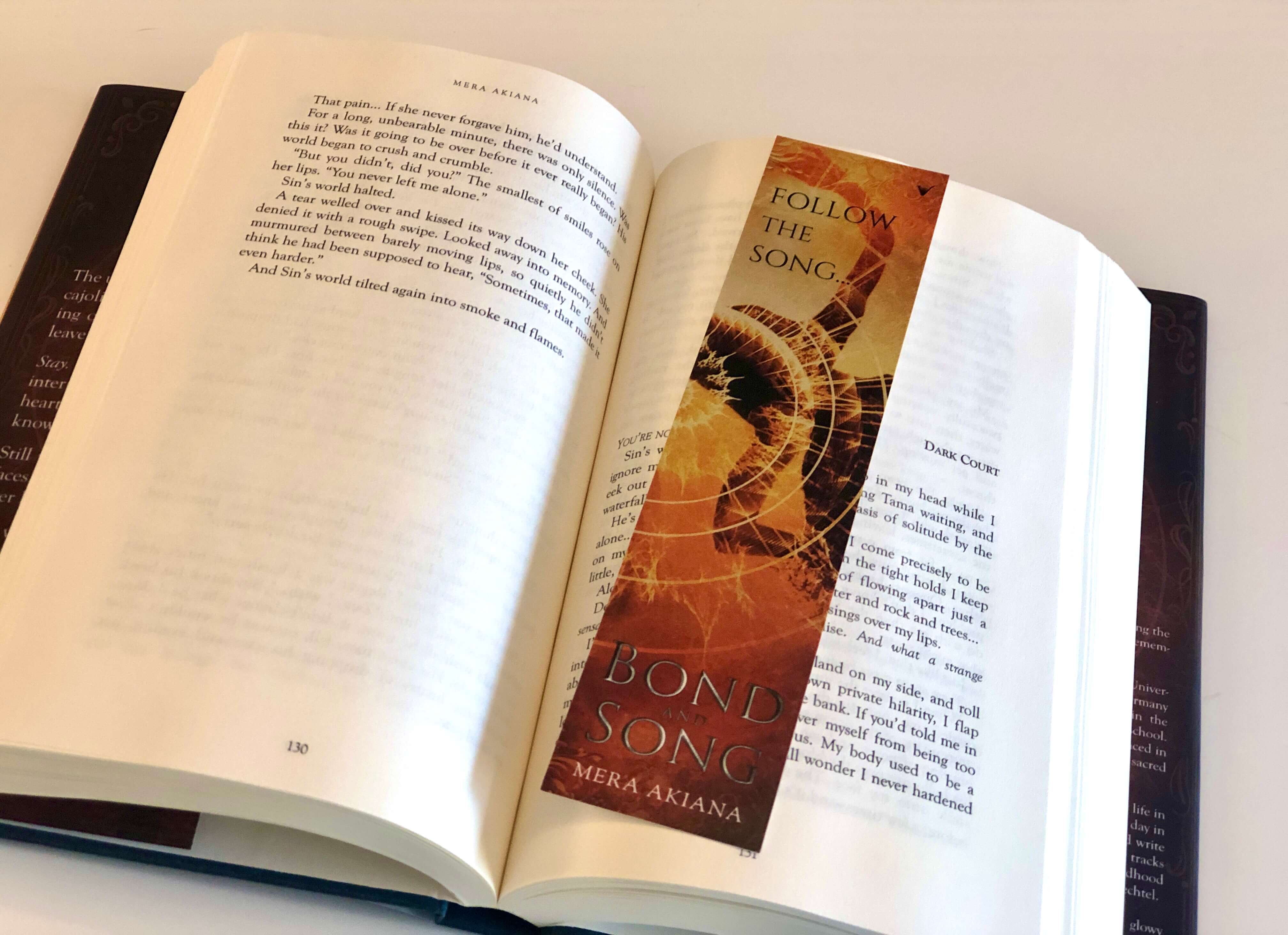 open hardcover of fantasy romance novel Bond and Song with matching bookmark