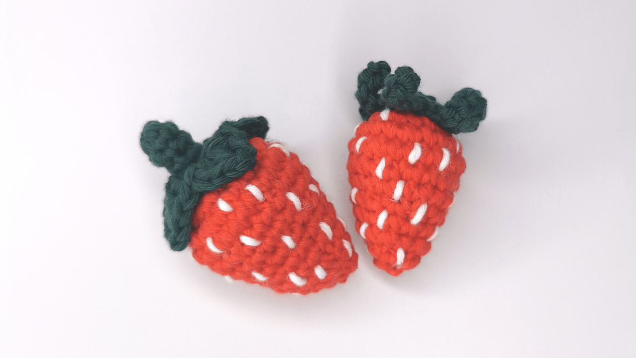 Two crocheted strawberries of different sizes. Succulent Strawberries free PDF crochet pattern.