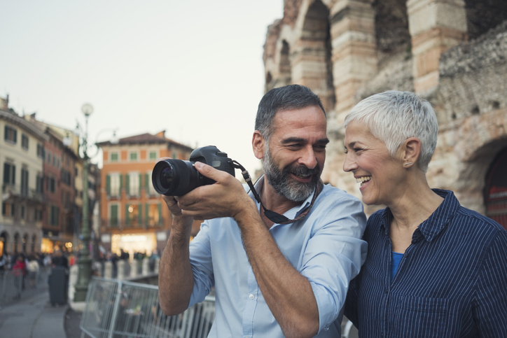 Two adult tourist visiting Verona: having a good time while taking pictures