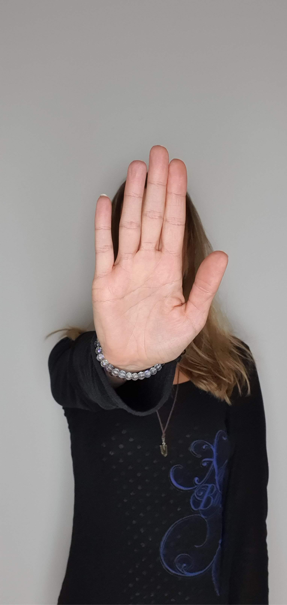 Frau streckt Handfläche nach vorne um Stopp zu signalisieren