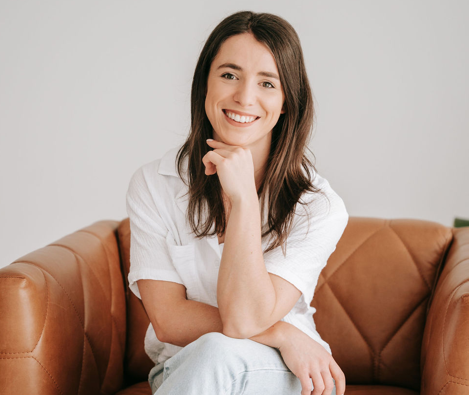 Dietitian sitting on leather couch smiling directly at camera