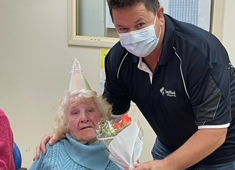 David and Maureen pose together with flowers at her birthday celebration
