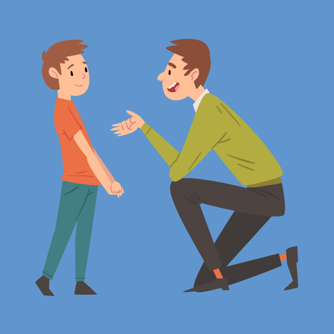 A man kneeling down to explain something to a child.
