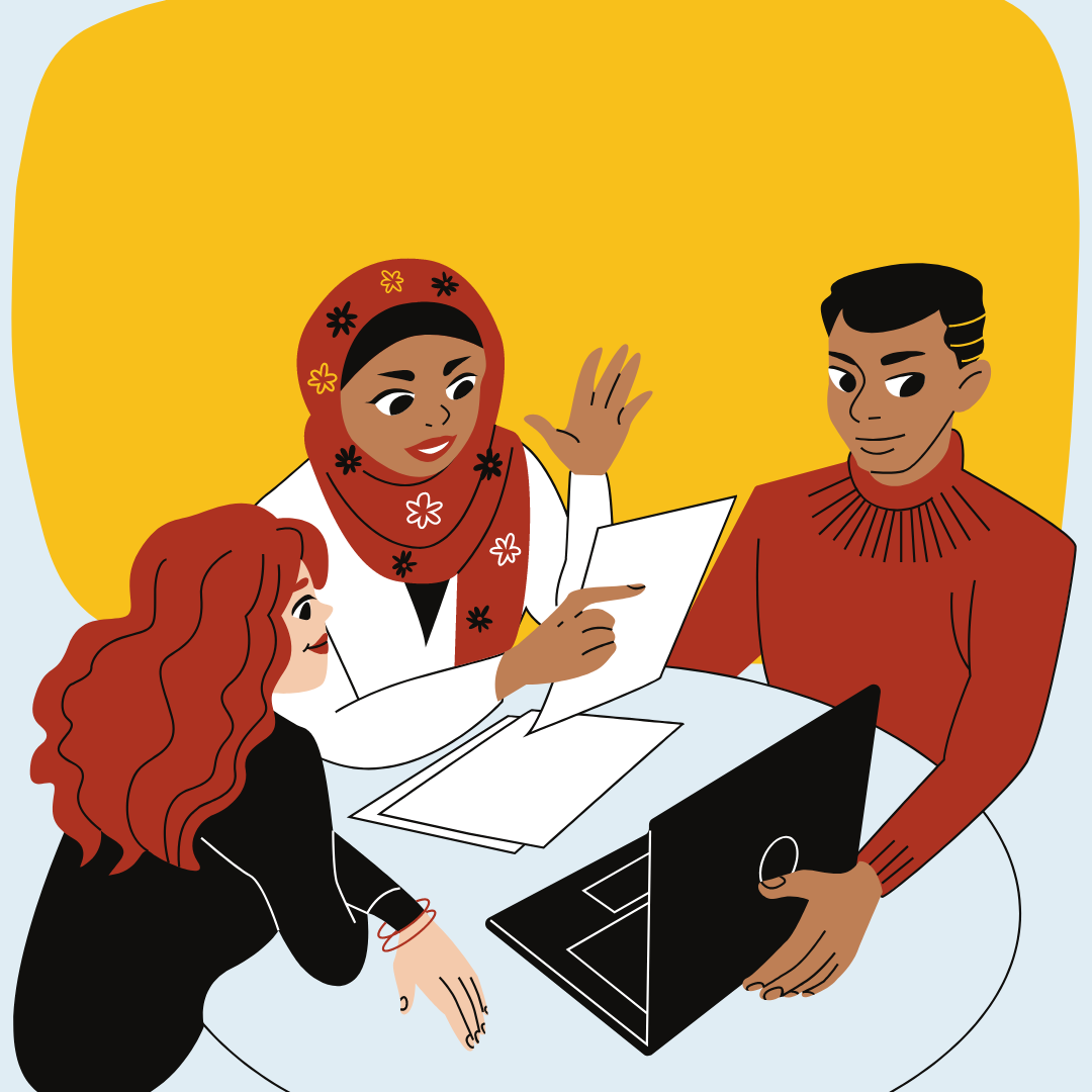A diverse trio of people working at a table around a laptop and a stack of papers.