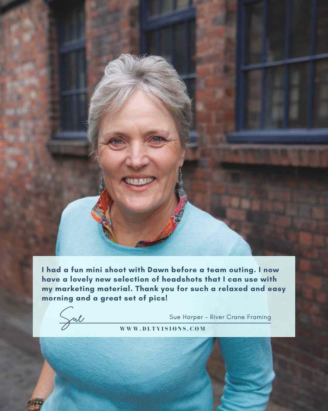 woman with grey hair wearing a pale blue jumper and smiling - brand image