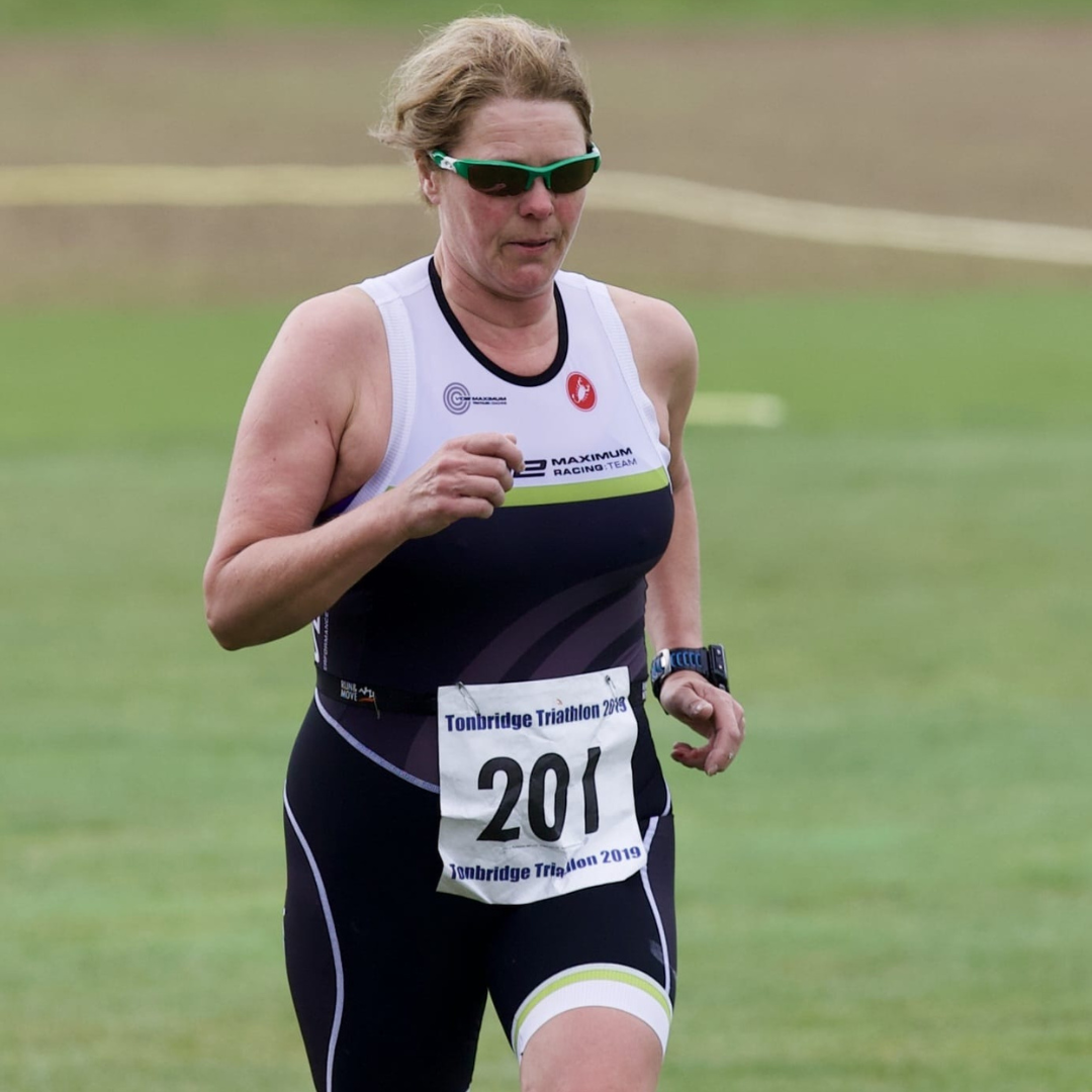 Triathlete running in race kit with a race number