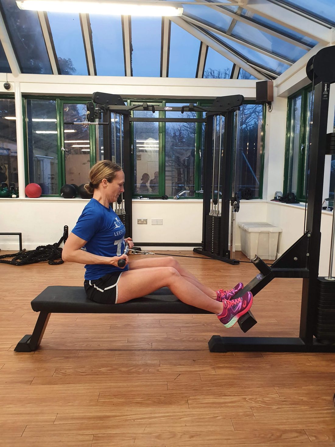 Client training on a rowing machine in the bright coaching studio