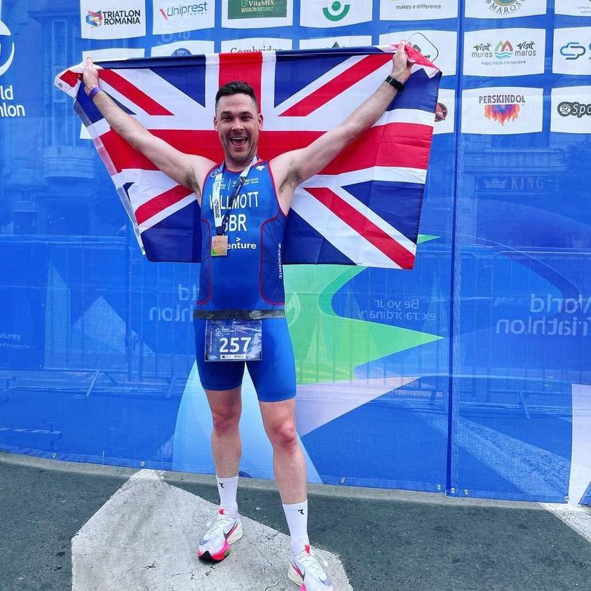 Triathlete on the podium holding the Union flag
