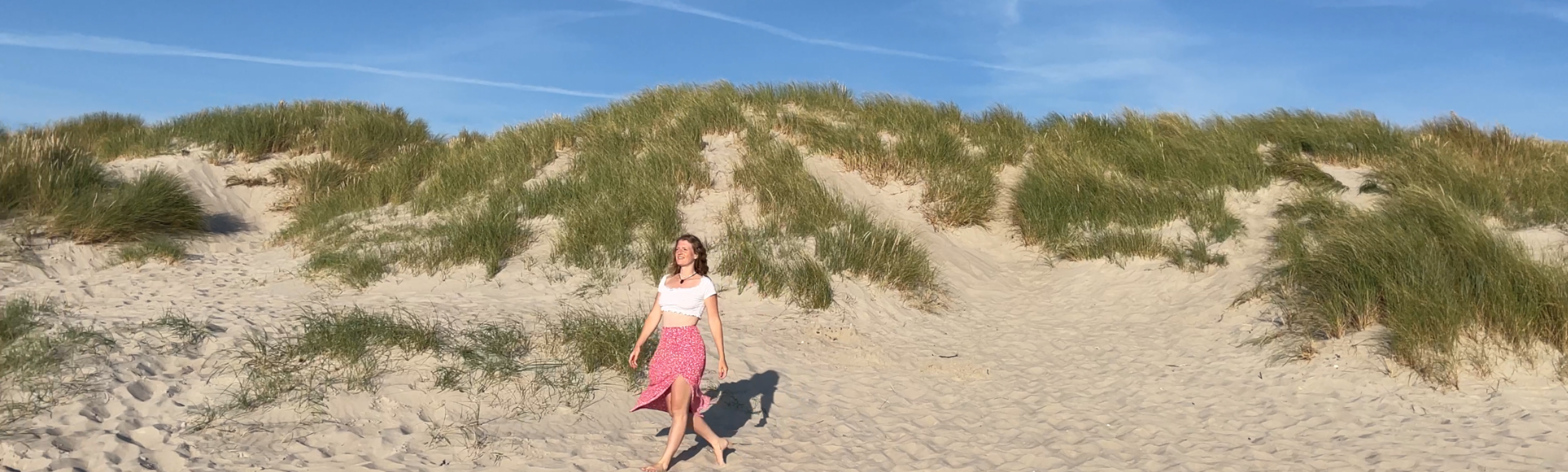 Julia walking barefoot through the dunes