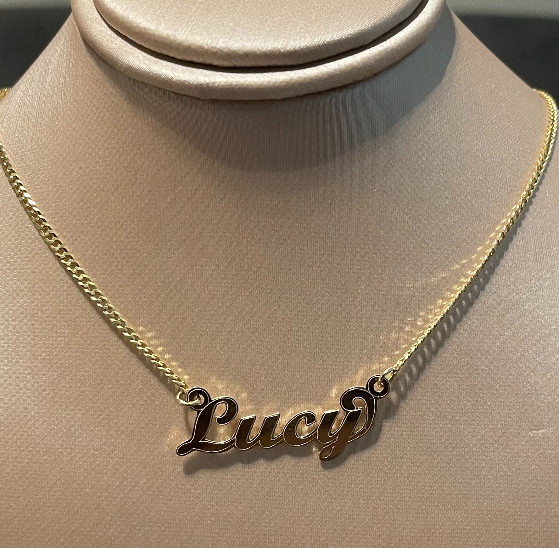 Personalized name in 14K Gold, Lucy, attached to a cuban link chain