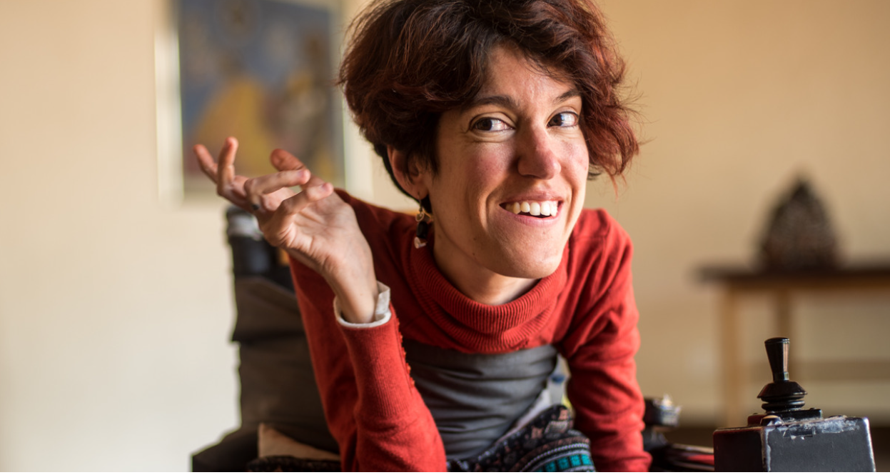 Woman leaning forward in wheelchair smiling