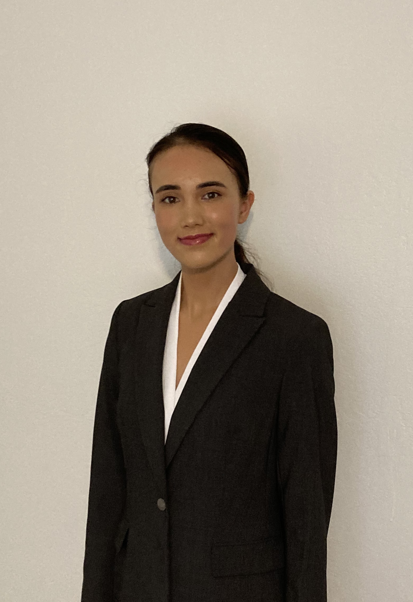 Picture of Erin Wiggins smiling, wearing a dark suit and white top.