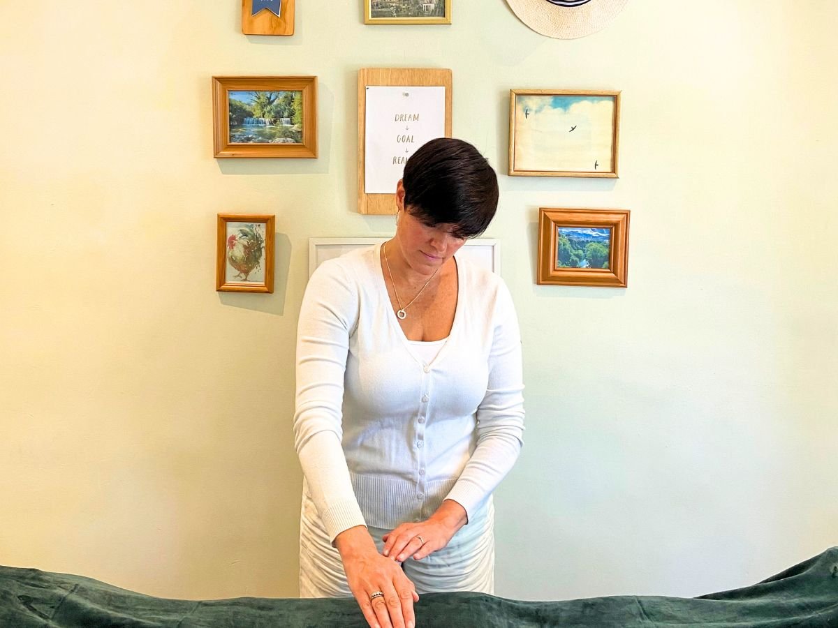 reiki-master-teacher-amy-orsini-standing-at-a-whiteboard-in-the-three-little-birds-reiki-room-purley-london-uk