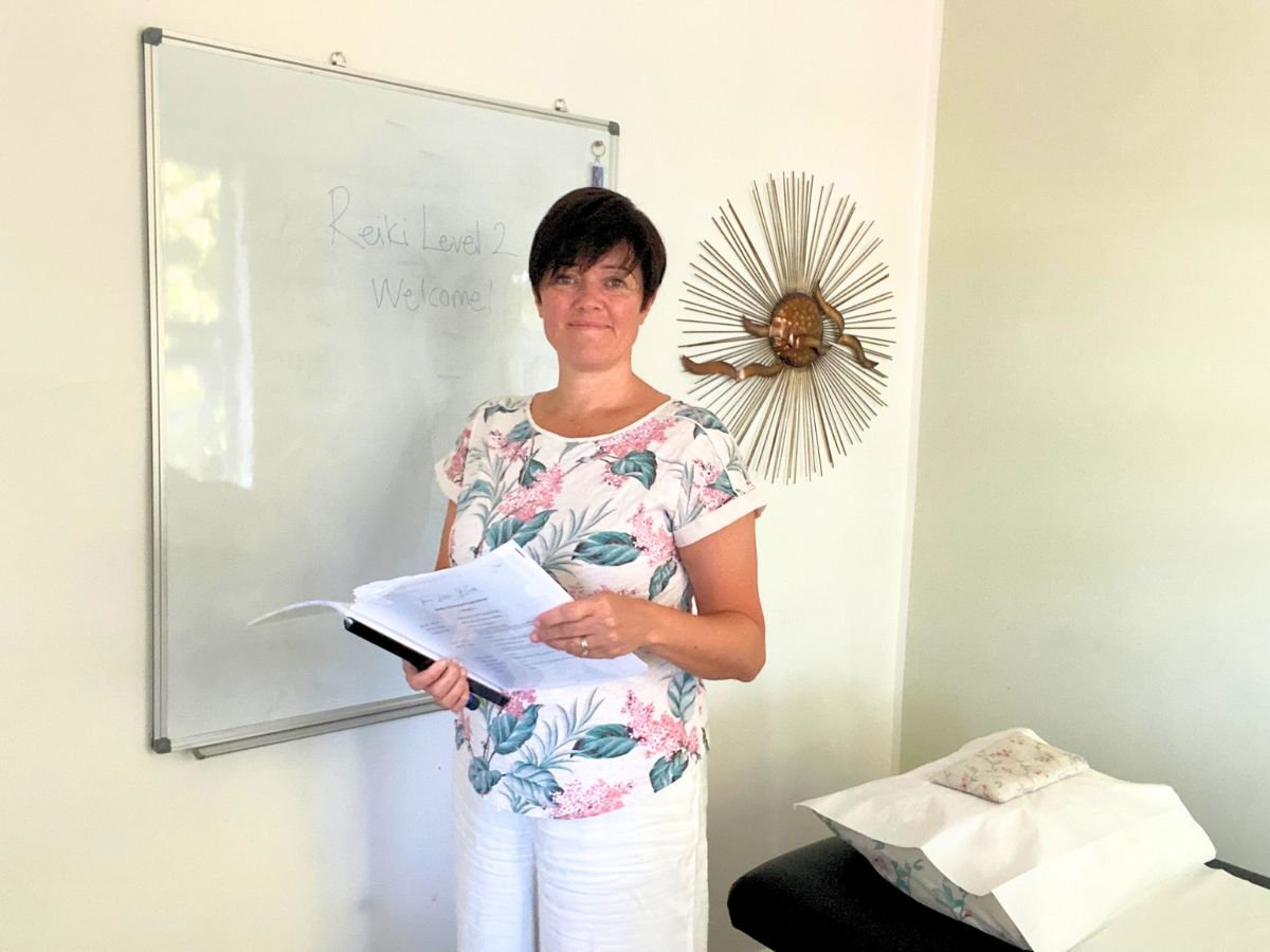 reiki-master-teacher-amy-orsini-standing-at-a-whiteboard-in-the-three-little-birds-reiki-room-purley-london-uk