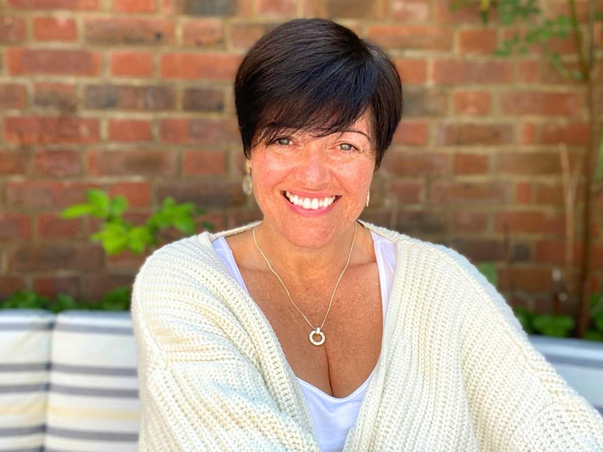 reiki master smiling at the camera in a beautiful garden