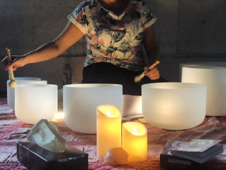 sound practitioner playing crystal singing bowls