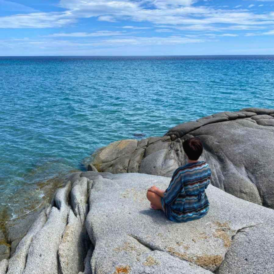 Reiki master meditating in front of the ocean