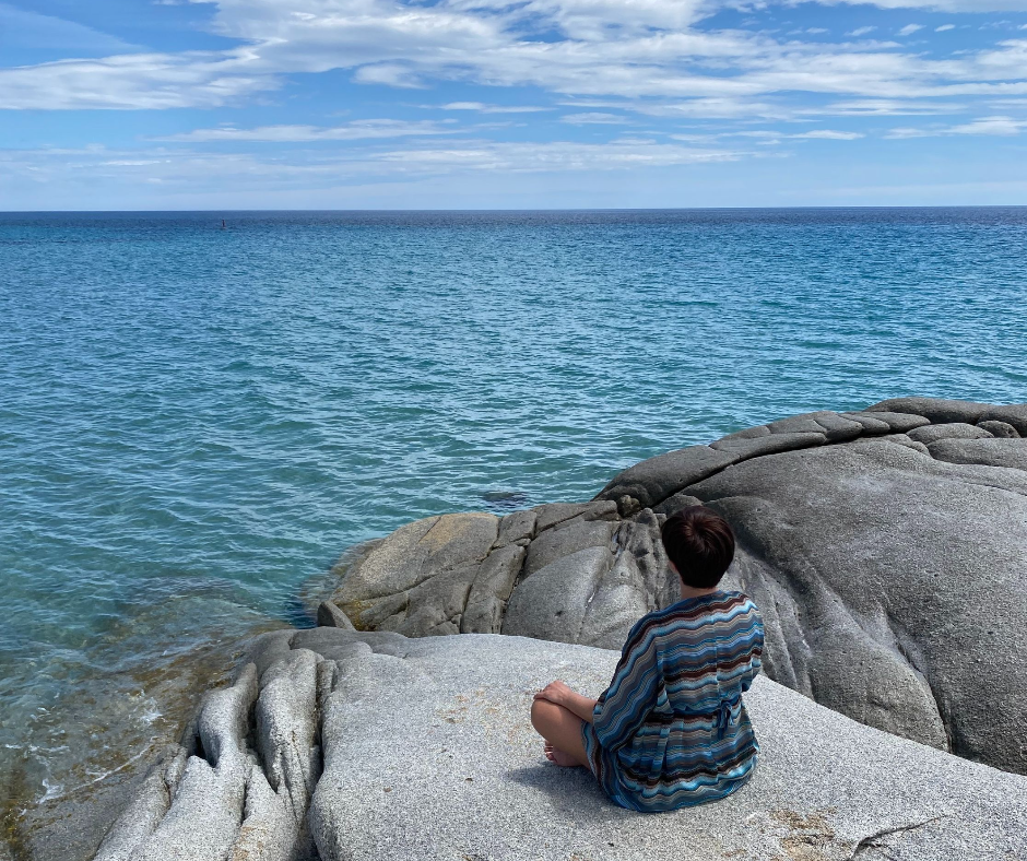 Reiki master meditating in front of the ocean