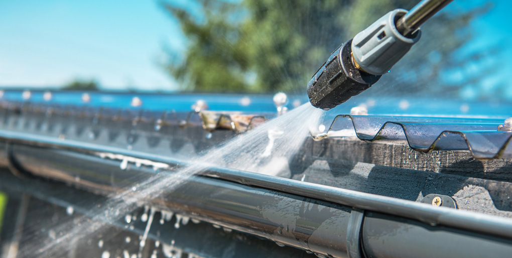 Pressure washer cleaning gutter