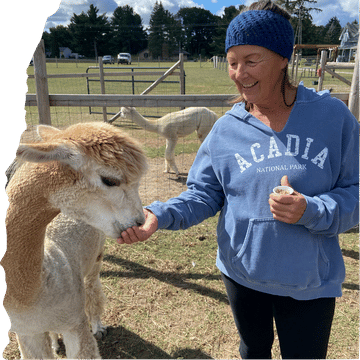 Nancy Carter of Making My Own Lane with an alpaca at a farm during her full-time RV travels