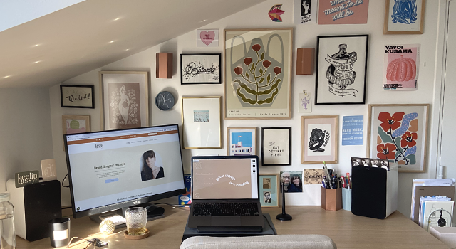 photo d'un bureau avec un écran à gauche, un ordinateur portable à droite et beaucoup de cadre au mur.