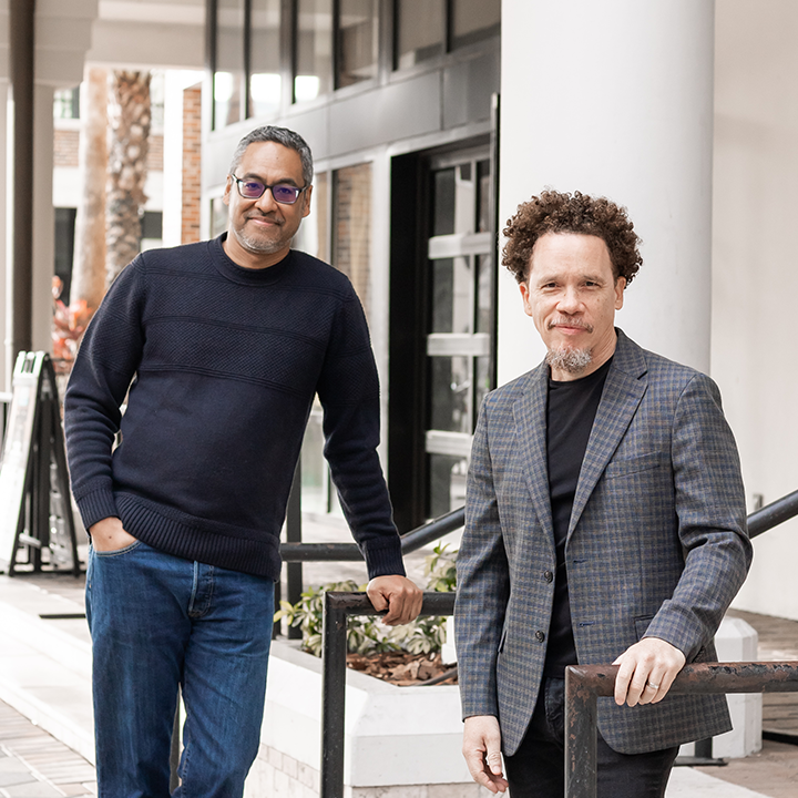 Co-Founders of The Ministry of Graphic Design a service of Media Sky Studio:  Christopher Coleman and Augusto Avila Jr. standing together in front of a downtown Orlando building.