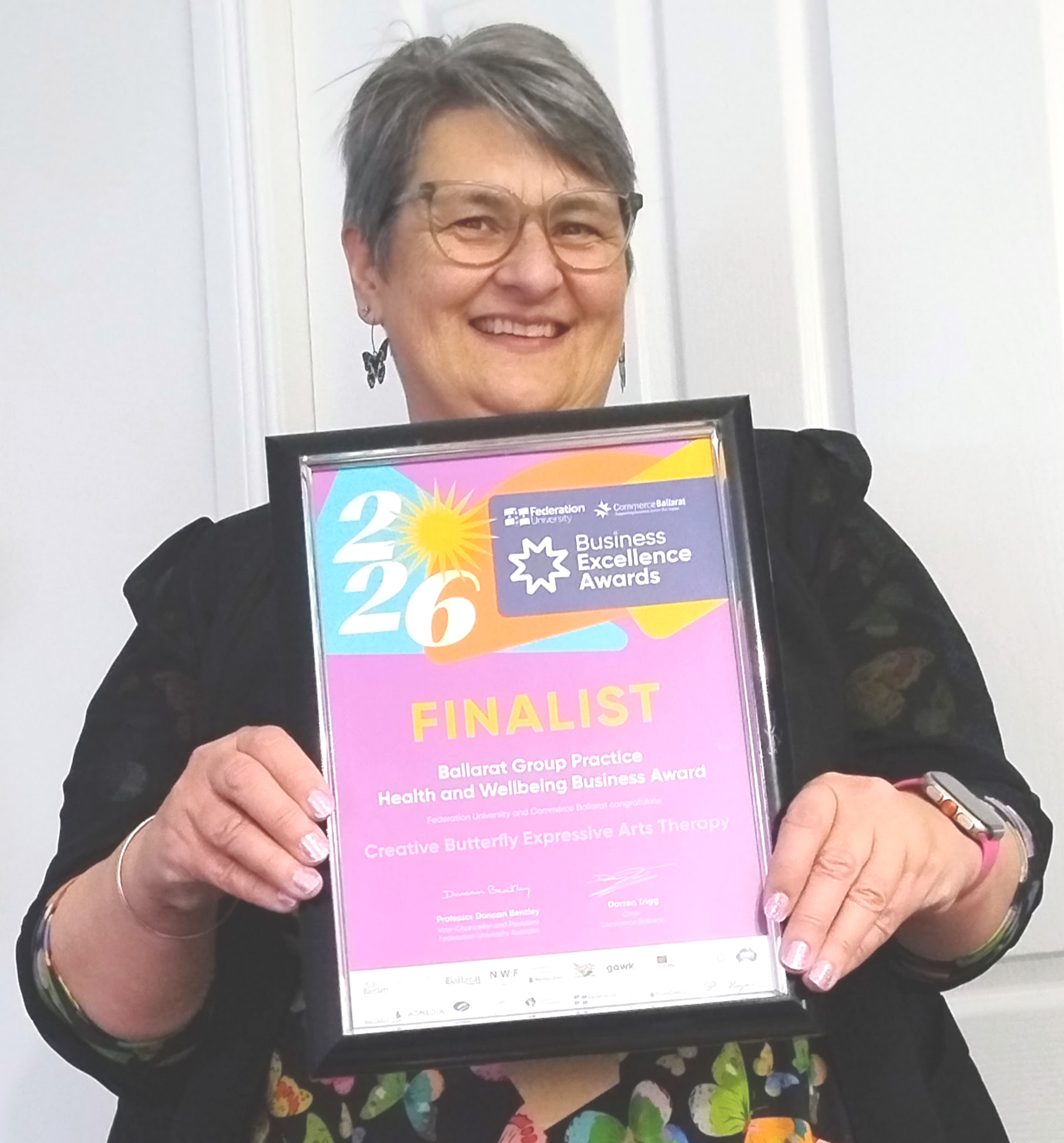 Fi Hocking holding her 2026 Federation University Commerce Ballarat Business Excellence Awards Finalist certificate for Creative Butterfly Expressive Arts Therapy