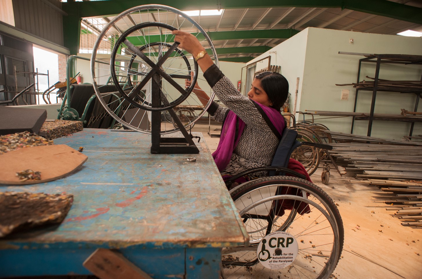 A woman in a wheelchair is building a wheelchair