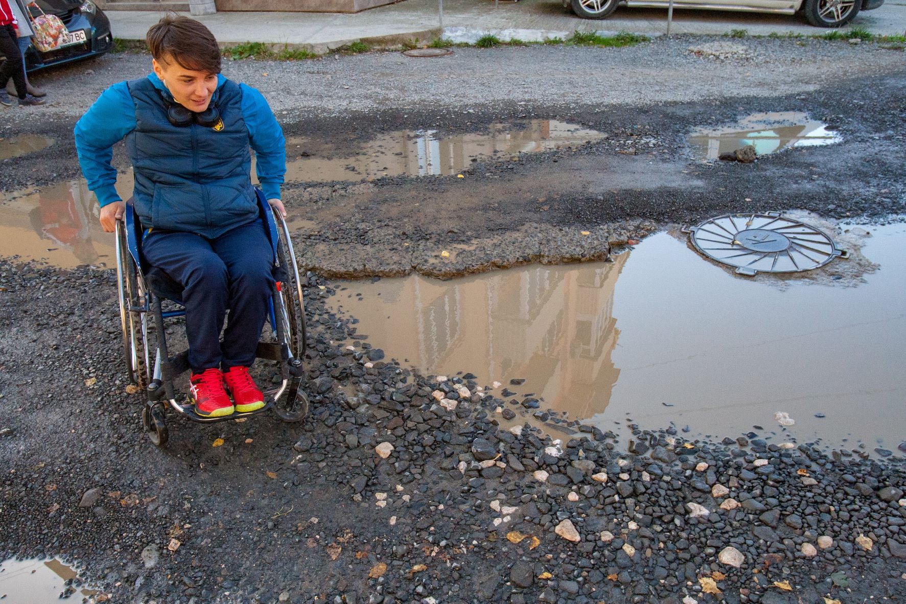 Woman sitting on a wheelchair on the scattered street