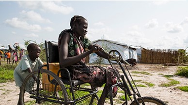 A child pulling a man in a improvised wheelchair