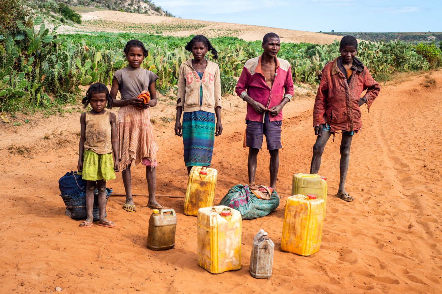 Water scarcity in the south remains a challenge in the area. A family, standing behind containers, had to walk miles to get water. © CBM/Viviane Rakotoarivony