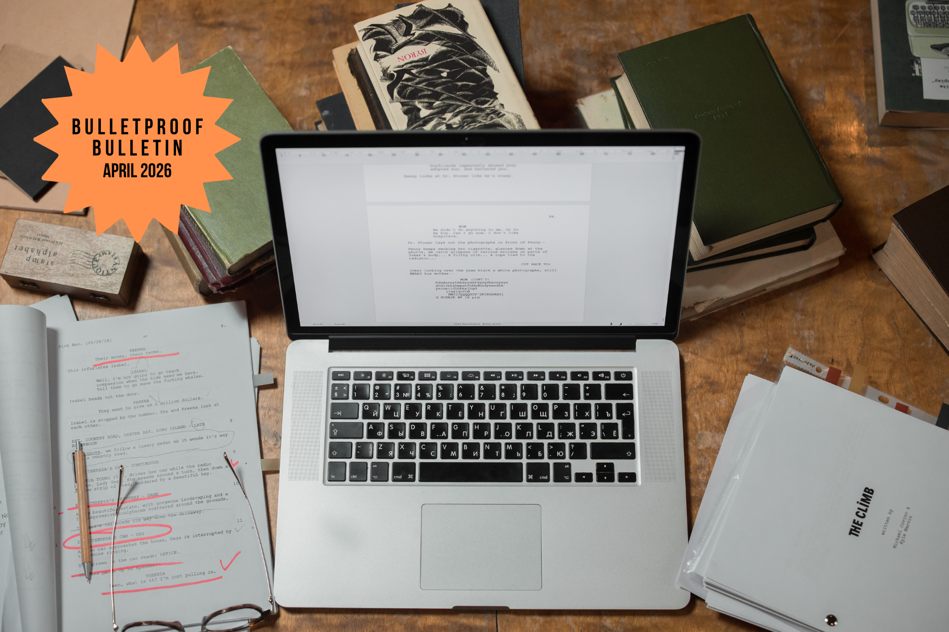 BulletProof Bulletin April 2026 newsletter graphic showing a laptop surrounded by stacked hardcover books, a printed script edited in pink pen, and reading glasses.