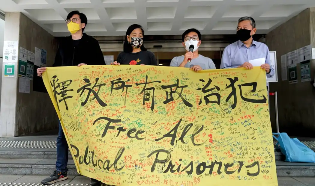 Protesters hold a banner reading 