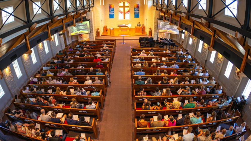 Arial picture of people sitting in pews in a traditional church building