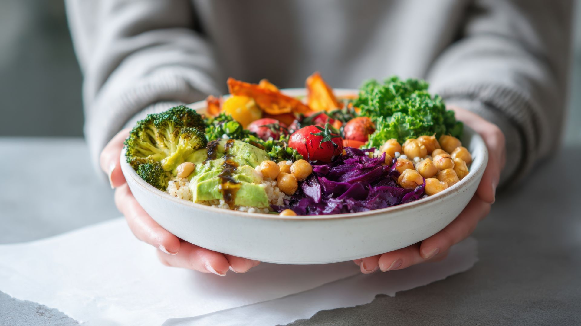 woman over 40 holding a nutritious, protein packed, salad with lots of colourful vegetables