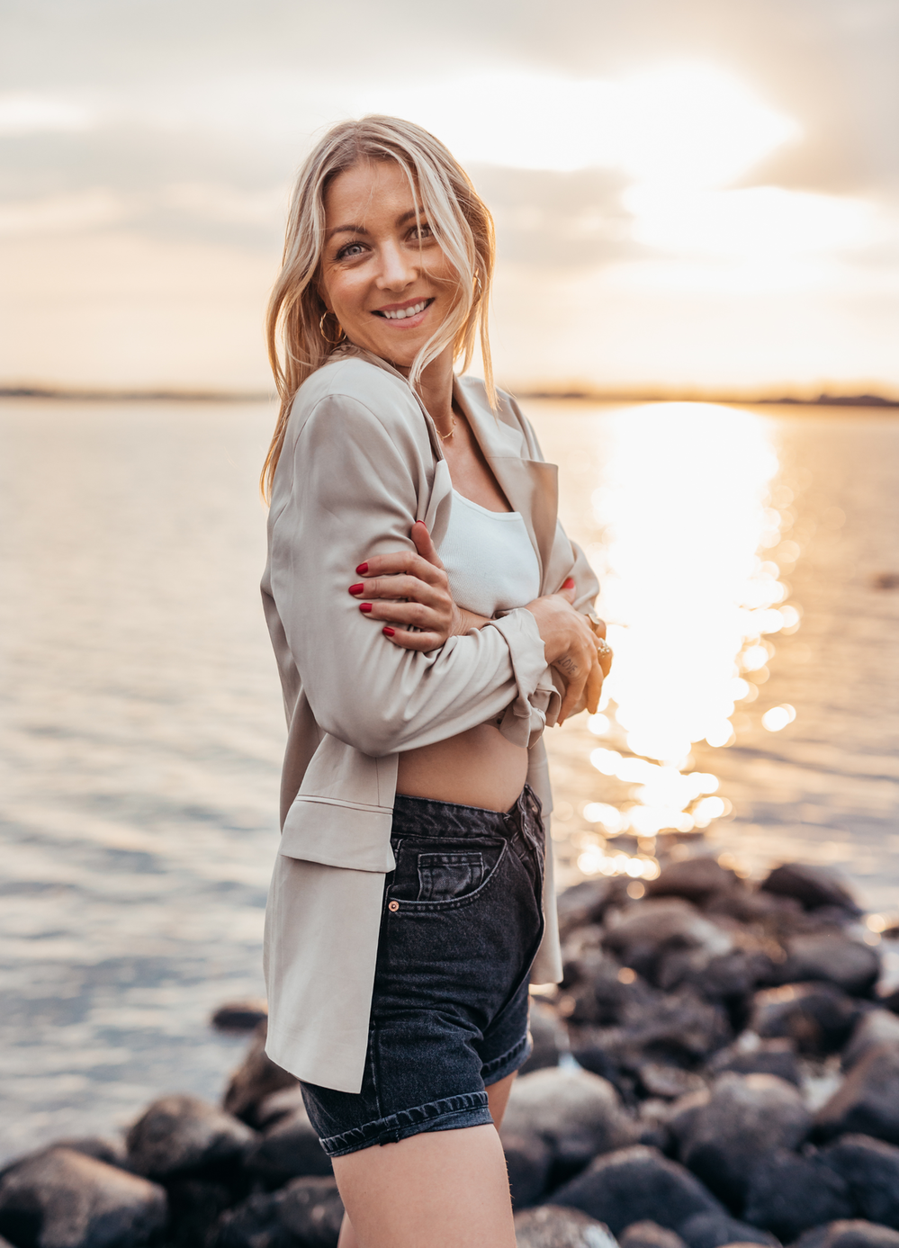 Picture of selfcare coach Luna Lova standing on rocks by the water