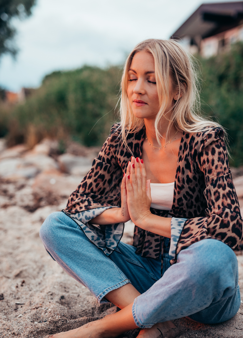 Picture of female selfcare coach Luna Lova sitting on beach