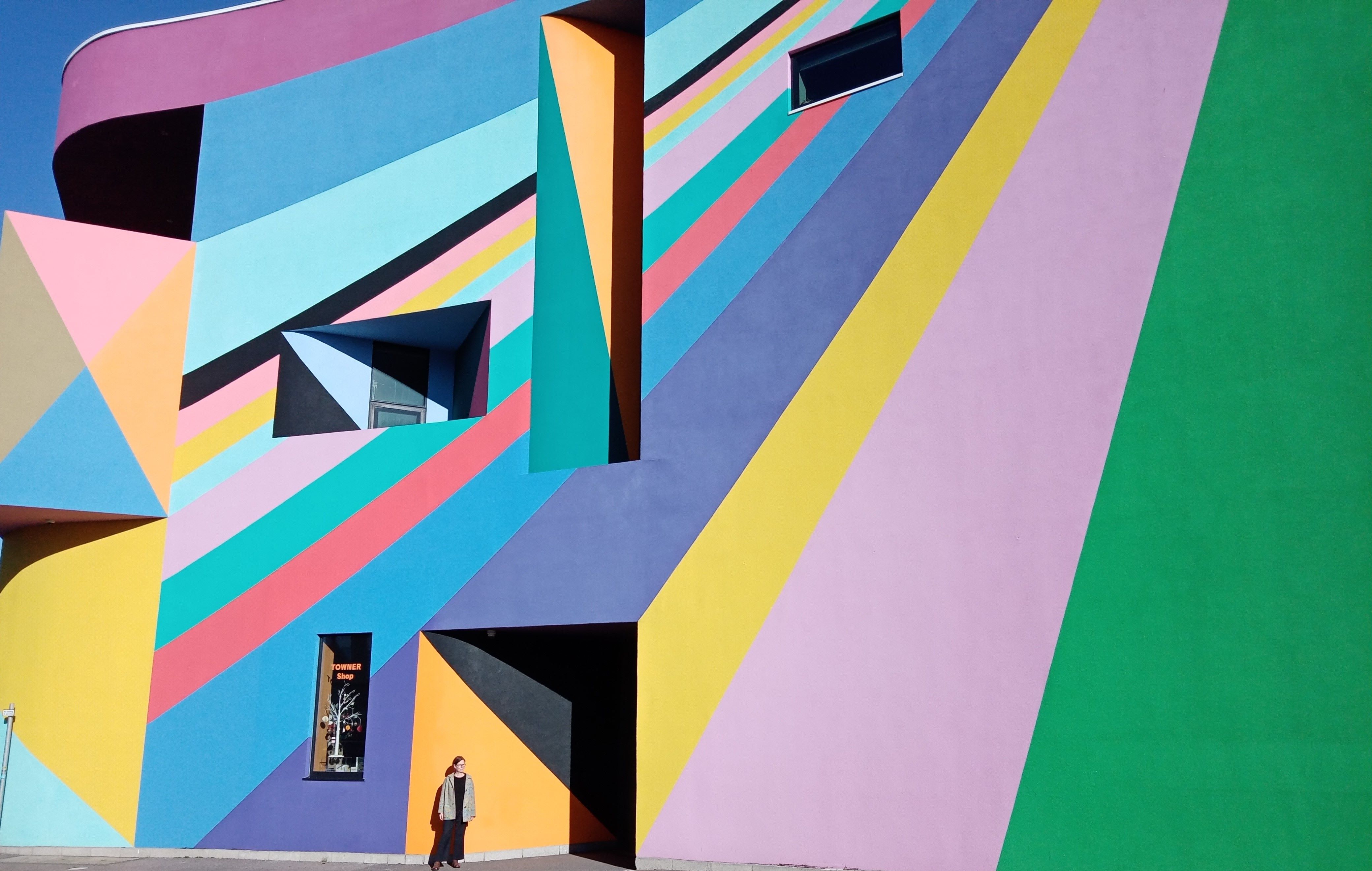 brightly coloured building with Julie standing in front