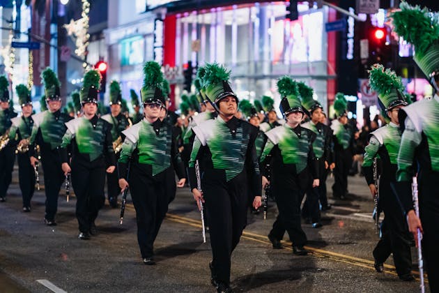A seasonal event parade, specifically showing Green & Silver holiday outfits, presented in the Near Me Discovery Events & Seasonal Highlights blog content hub as the image for the Holiday Season Events in PCB & Nearby blog post