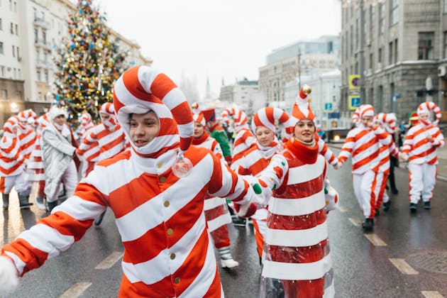 A seasonal event parade, specifically showing Christmas holiday decorations and costumes and similarly themed outfits, presented as the Near Me Discovery Events & Seasonal Highlights blog content hub image