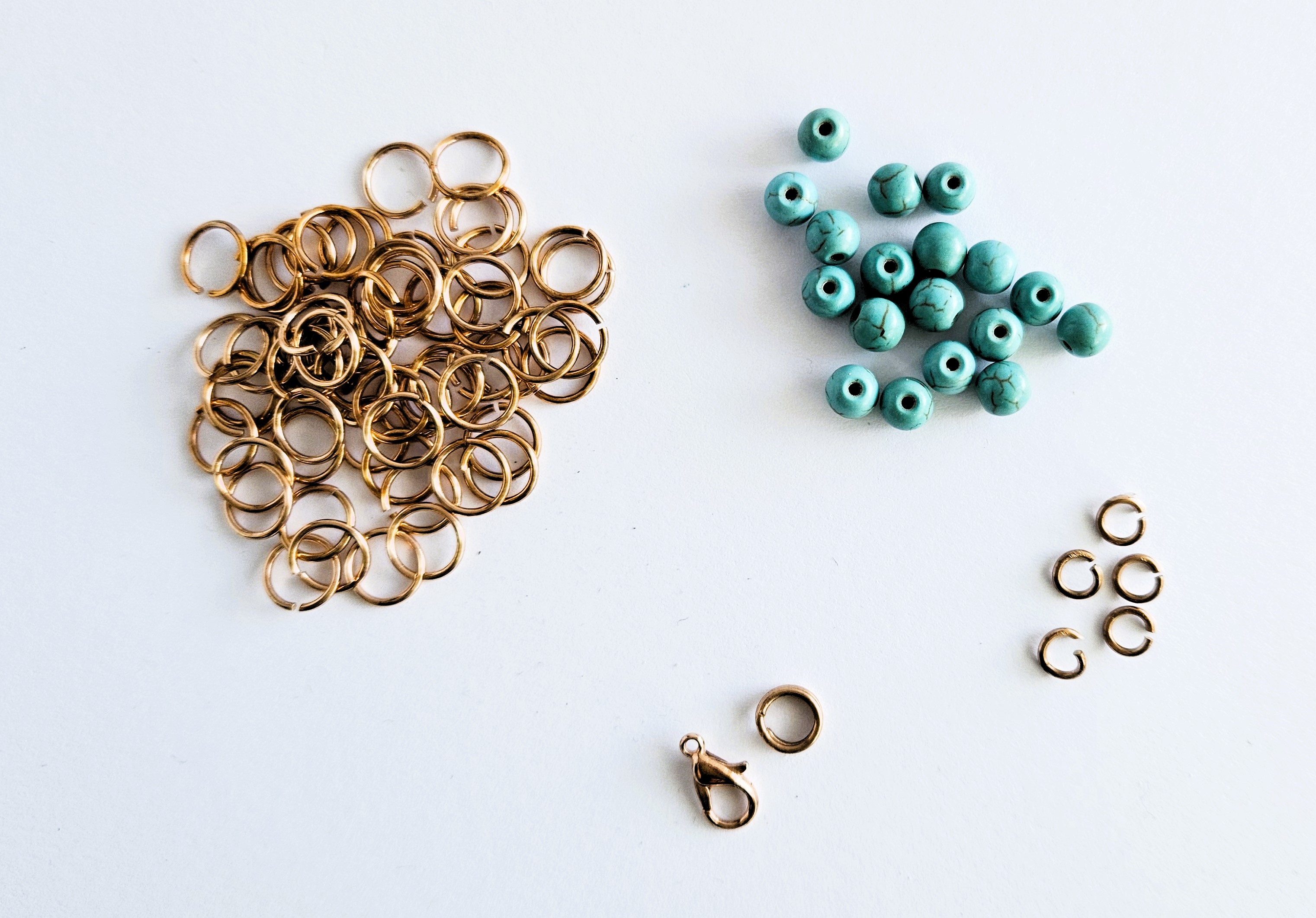 materials for making a captured beads bracelet: bronze jump rings, clasp, turquoise beads