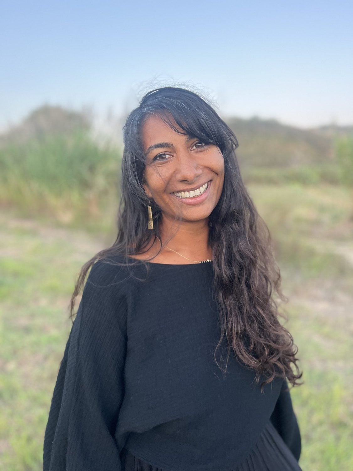Portrait de Davina, souriante, dans un champ