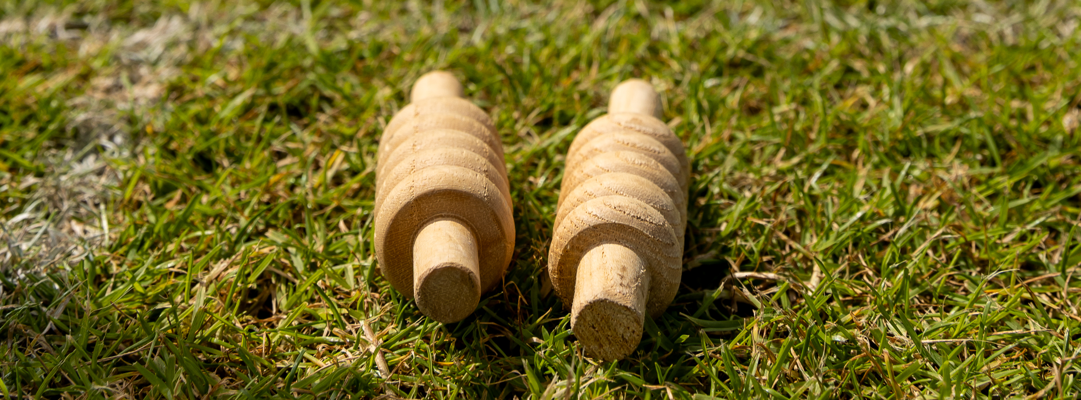 Two cricket bails laying on the grass