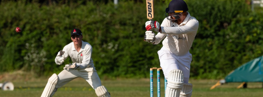 Adult batsman hitting a ball down leg side past a wicket keeper