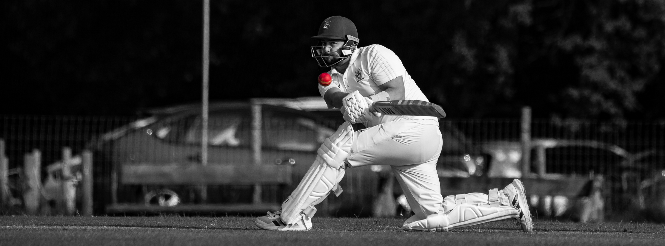 Male batter in full stretch hitting the ball leg side