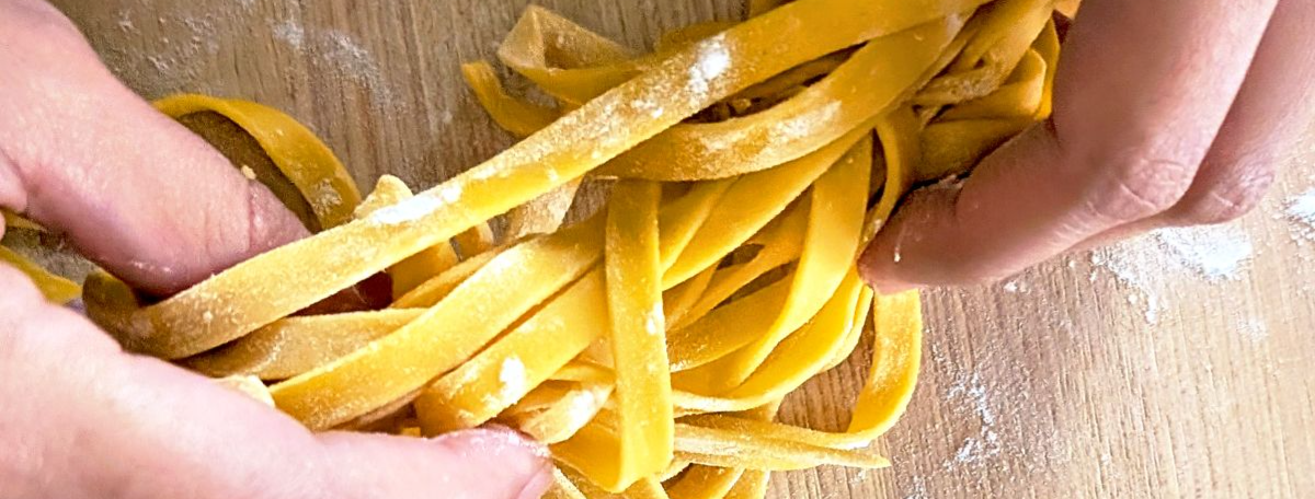 Lightly floured handmade fresh pasta noodles being picked up