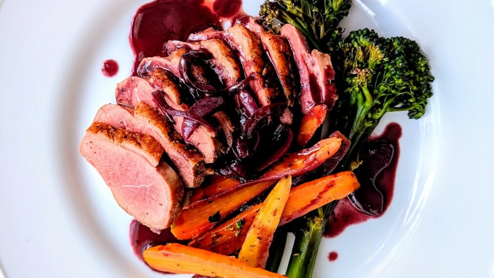 Duck breast with red wine pan sauce and vegetables