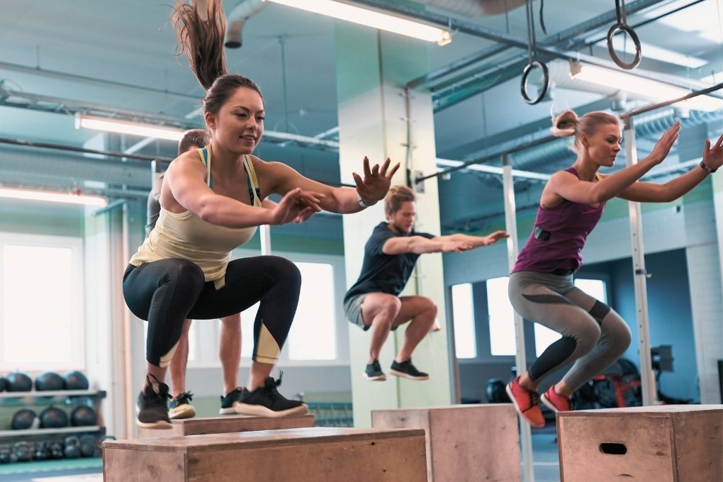 ALT-Text: Gruppe von Menschen beim Box-Jump-Training im Fitnessstudio – effektives Kraft- und Sprungtraining zur Förderung von Muskelaufbau, Stoffwechsel und Knochengesundheit in der Perimenopause.